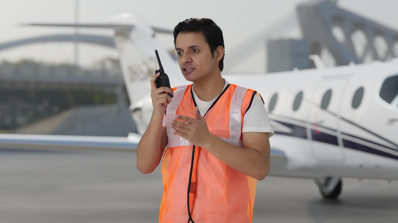 화난 인도 공항 지상 직원 노동자가 워키 토키에 소리쳤다.