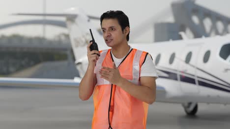 el trabajador del personal de tierra del aeropuerto indio enojado gritando en el walkie talkie