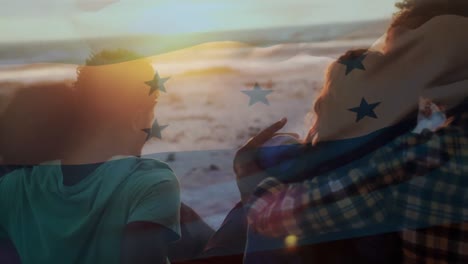 Animation-of-waving-flag-of-honduras-over-group-of-friends-having-fun-on-the-beach