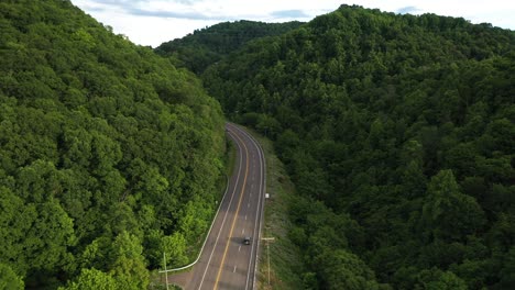 aerial view of thick green forest and quiet traffic on highway in virginia usa