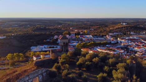 fotografía de un dron de una antigua torre medieval en una colina cerca de un pueblo en alentejo, portugal