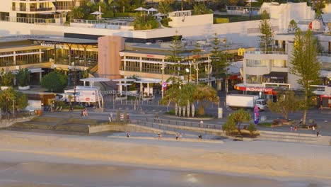 aerial view of gold coast boardwalk at sunrise, capturing morning light, beach, and urban landscape. calm and serene atmosphere