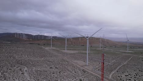 imágenes aéreas de un parque eólico en el desierto de palm springs en un día nublado, toma lenta