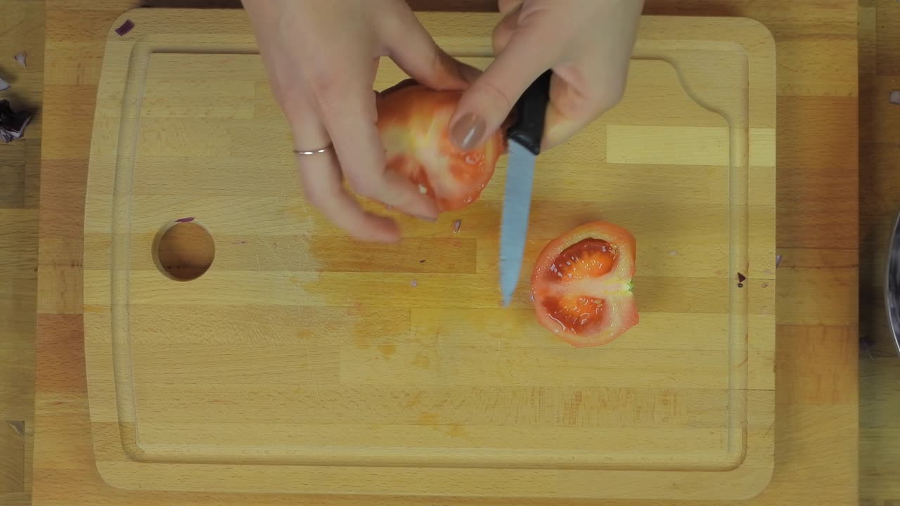 Woman Chopping Tomato at Wooden Kitchen Table