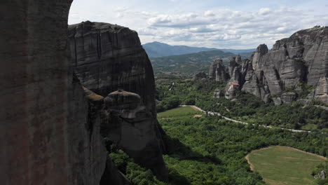 Close-up-drone-flight-near-rock-pillar-formation-revealing-Meteora-valley-Region-Greece-sunny-day