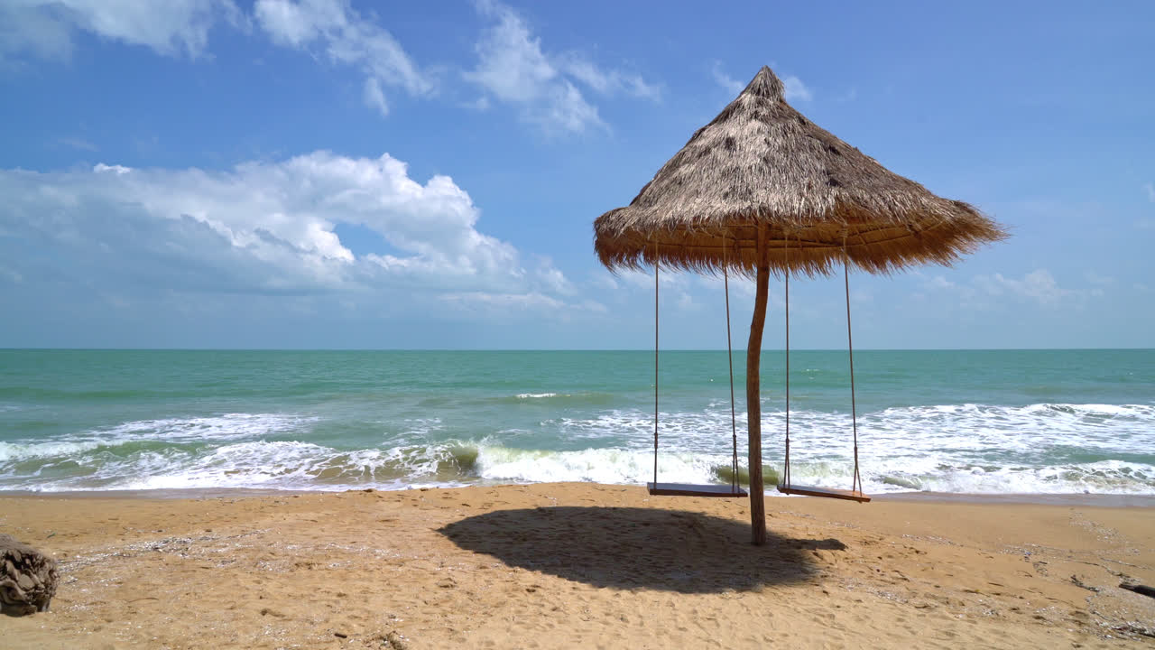 columpio en la playa con mar océano y fondo de cielo azul