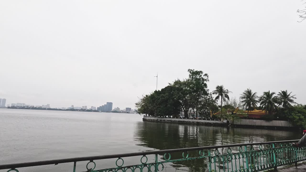 오토바이와 보행자는 경치 좋은 강길을 따라 이동합니다.