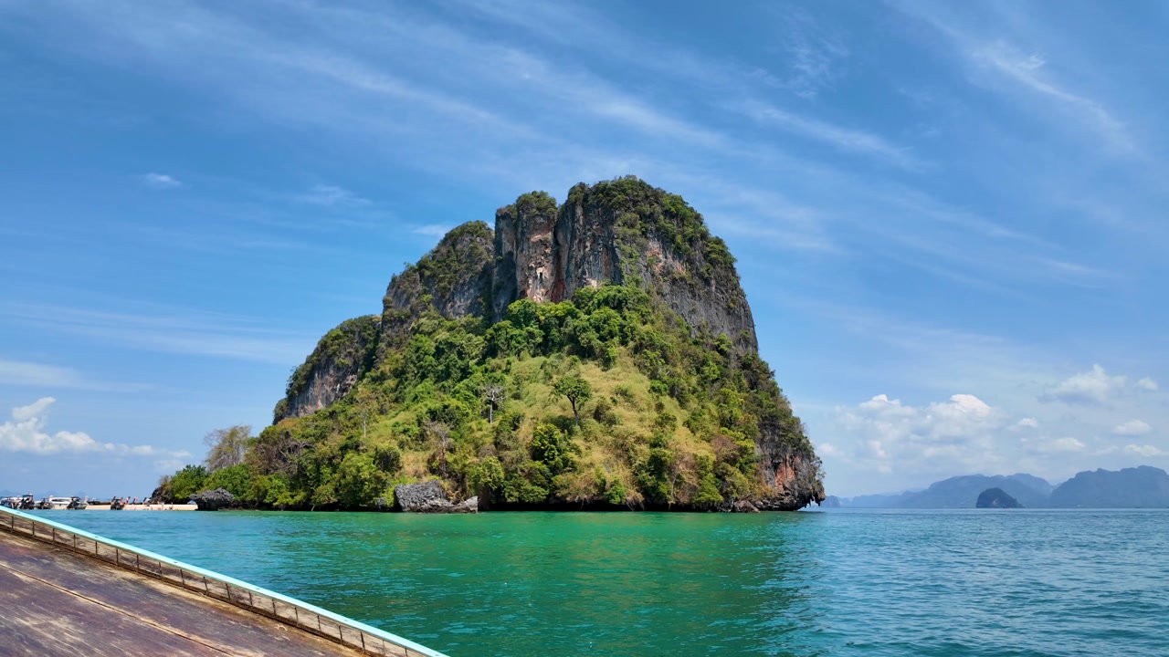 Point of view from traditional longtail boat heading toward limestone island at Koh Hong Krabi Thailand with calm sea clear sky and tropical scenery in the Andaman Sea