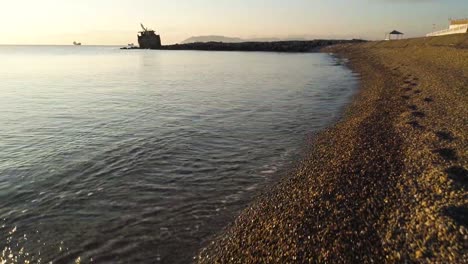 sunrise at a rocky beach with sea and construction