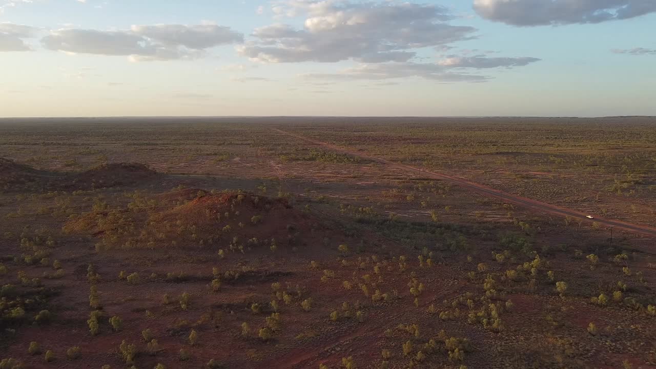 Aerial Shot of a Car Driving Down a Solitary Road in the Outback