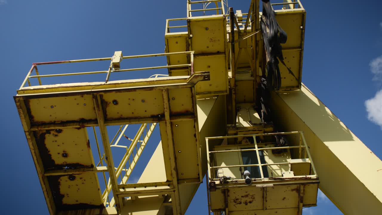 Detailed view of an old yellow container crane in Park Spoor Oost, Antwerp, with rust and wear