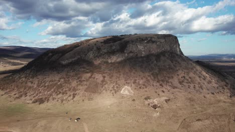 aerial, low angle shot of a cliff standing out in the romanian landscape