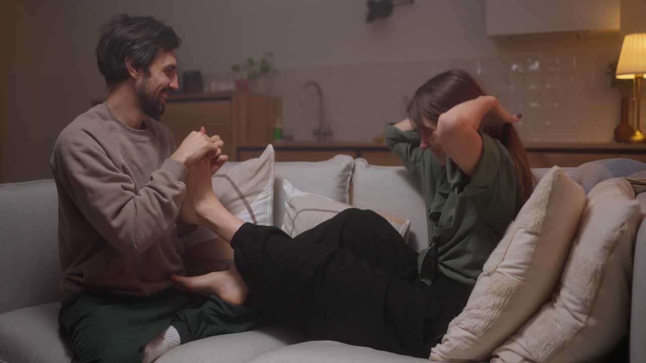 부부 가 집 에서 발 마사지 를 즐기고 있다