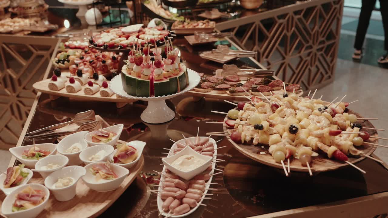 Tavolo da buffet per catering con antipasti, dessert e spiedini al chiuso