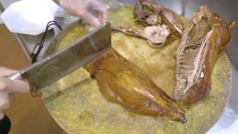 chopping roasted goose on a wooden board - top view