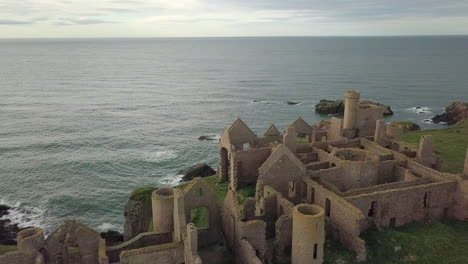 Aerial-view-of-a-Slains-Castle-ruin-at-sunrise,-Aberdeenshire,-Scotland