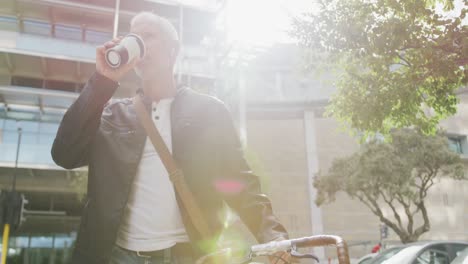 caucasian man out and about in the city street drinking a coffee