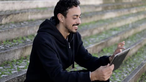 Smiling young man using digital tablet