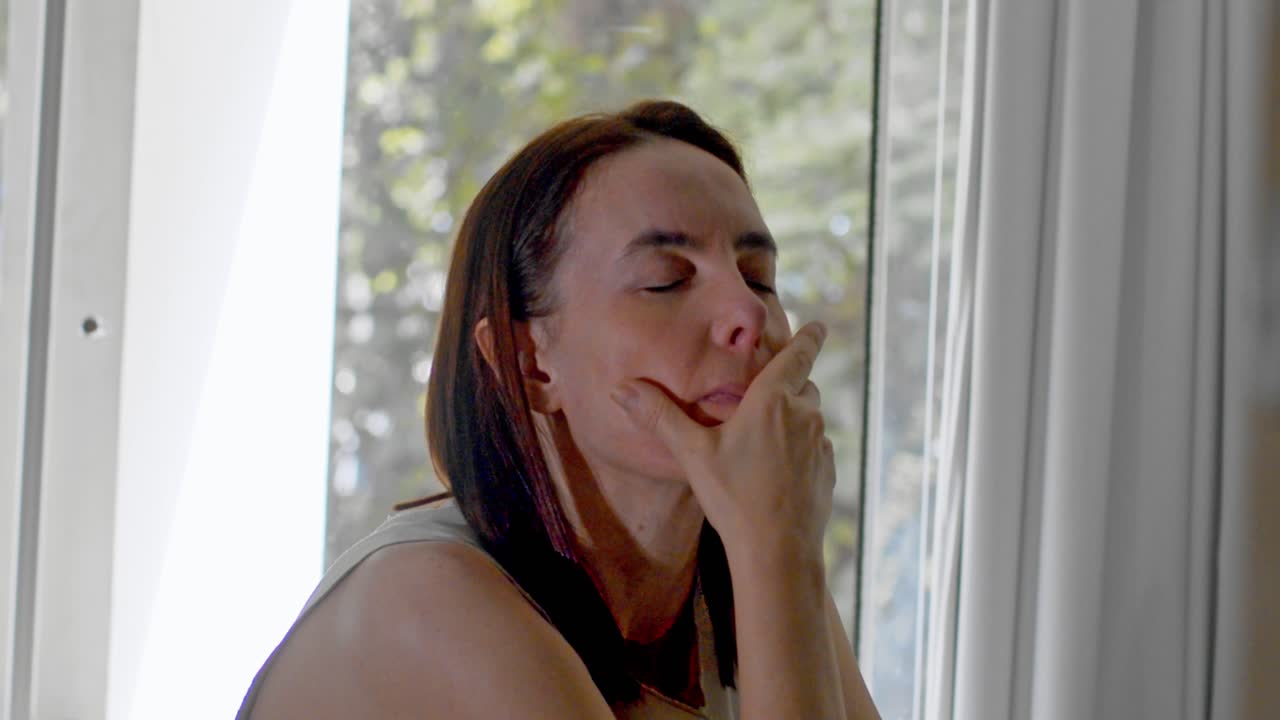 el dolor de cabeza y cuello parece estar afectando a una mujer de mediana edad.