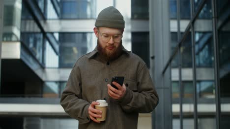 hombre usando teléfono inteligente con café