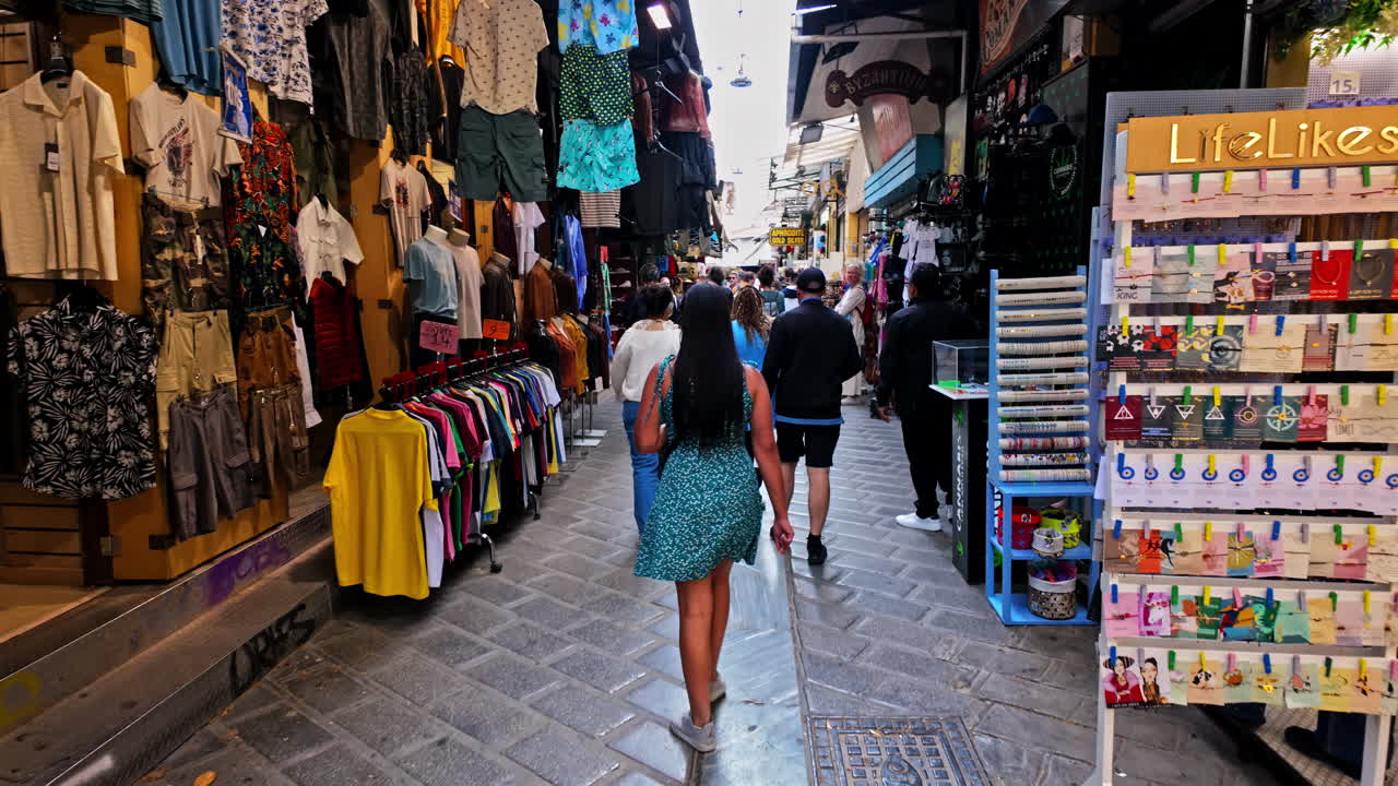 People Shopping in a Busy Outdoor Marketplace with Clothing Stalls