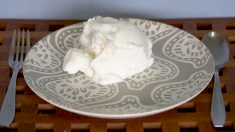 unappetizing blob of vegetable shortening falls on empty plate, slow motion