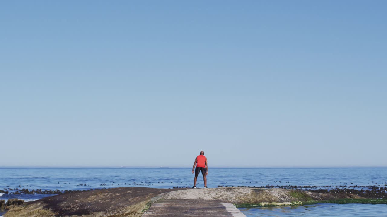 시니어 아프리카계 미국인 남자가 바 ⁇ 가에서 손을 들어 올리는 연습을 하고 있습니다.
