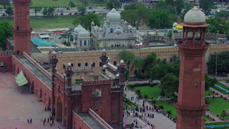 lahore, pakistan, badshahi mosque aerial view by the minarets, showing gurdwara of the sikhs, street and city traffic, visitors ladies, gents and children are in the mosque