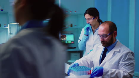 Chemist-nurse-holding-test-tubes-bringing-to-doctor