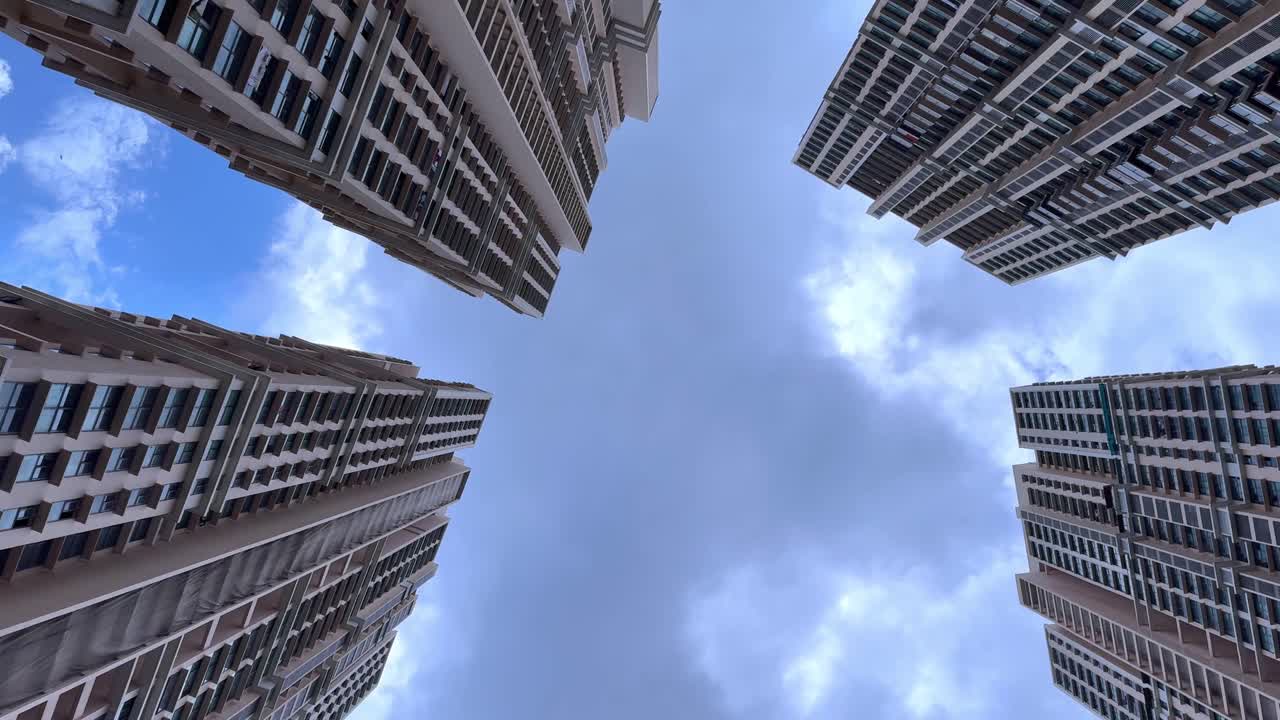 Clouds passing over high rise Mumbai apartments in time lapse, view from ground. Apt for real estate, city life and urban development concept