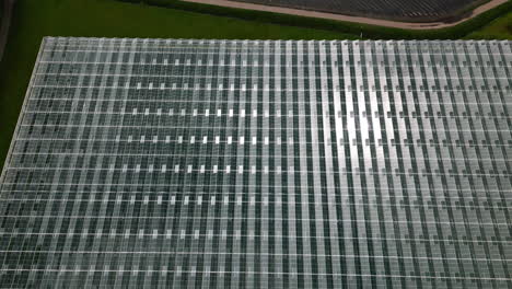 Sol-Reflejado-En-Un-Enorme-Complejo-De-Casas-Verdes,-Vista-Aérea-De-Drones