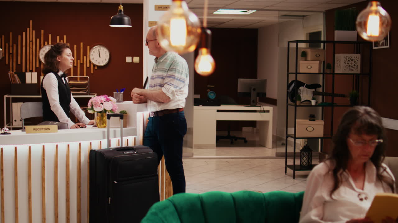 adulto mayor registrándose en el vestíbulo del hotel