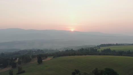 drone shot of sunrise above hills, forest and mountains in czech countryside