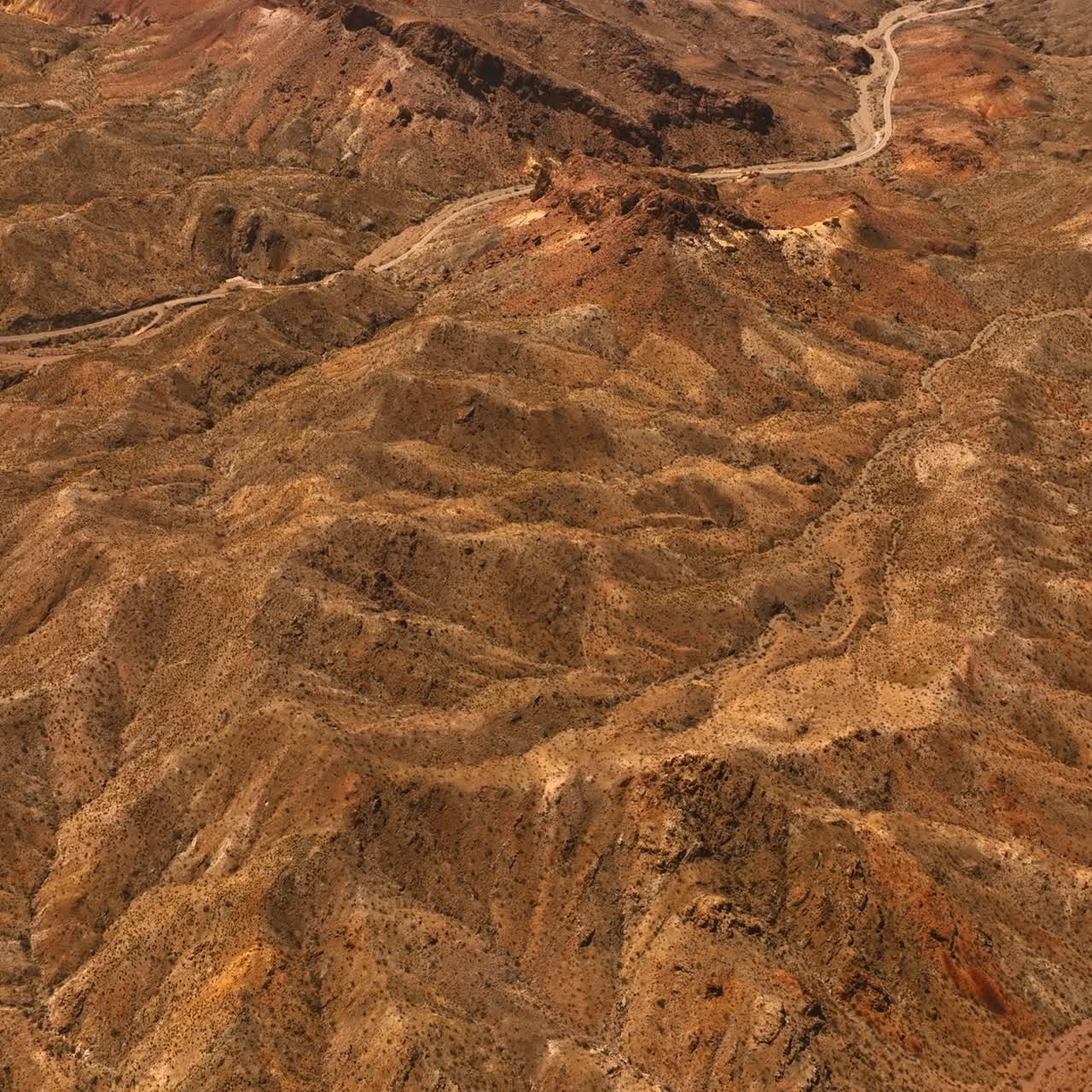 Lifeless deserted rocky landscape with no vegetation. Drone footage above the Mojave desert at daytime
