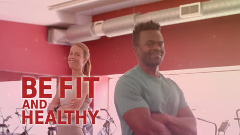 animation of be fit and healthy text over happy diverse man and woman in gym