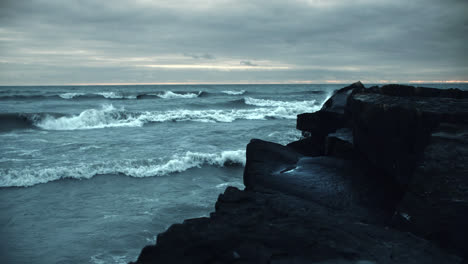 powerful iceland storm waves crashing against black beach rock cliffs