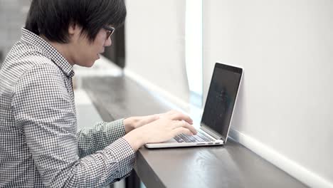 young asian business man using laptop computer in working space. male hand typing password on laptop keyboard for log in. freelance lifestyle in digital age concept.