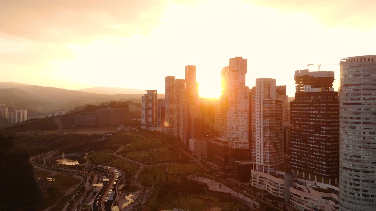 Raios de sol entre os arranha-céus e edifícios altos de Santa Fé a partir de uma vista aérea de drone no México