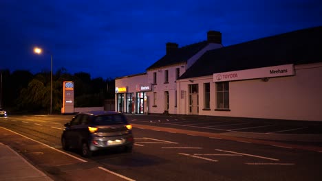 view of the road and auto parts store, cars pass by the street in dundalk , ireland