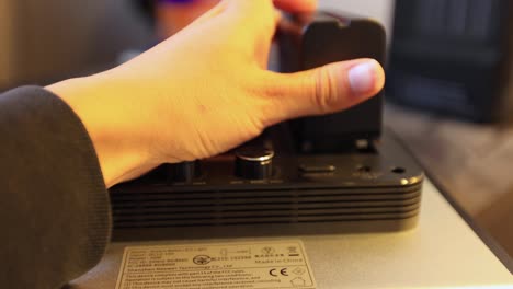 colocando una bateria en una luz led para fotografia 4k