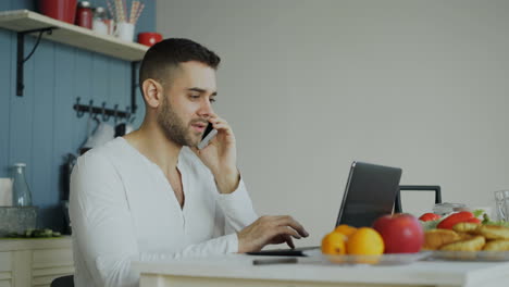 man working at home in kitchen