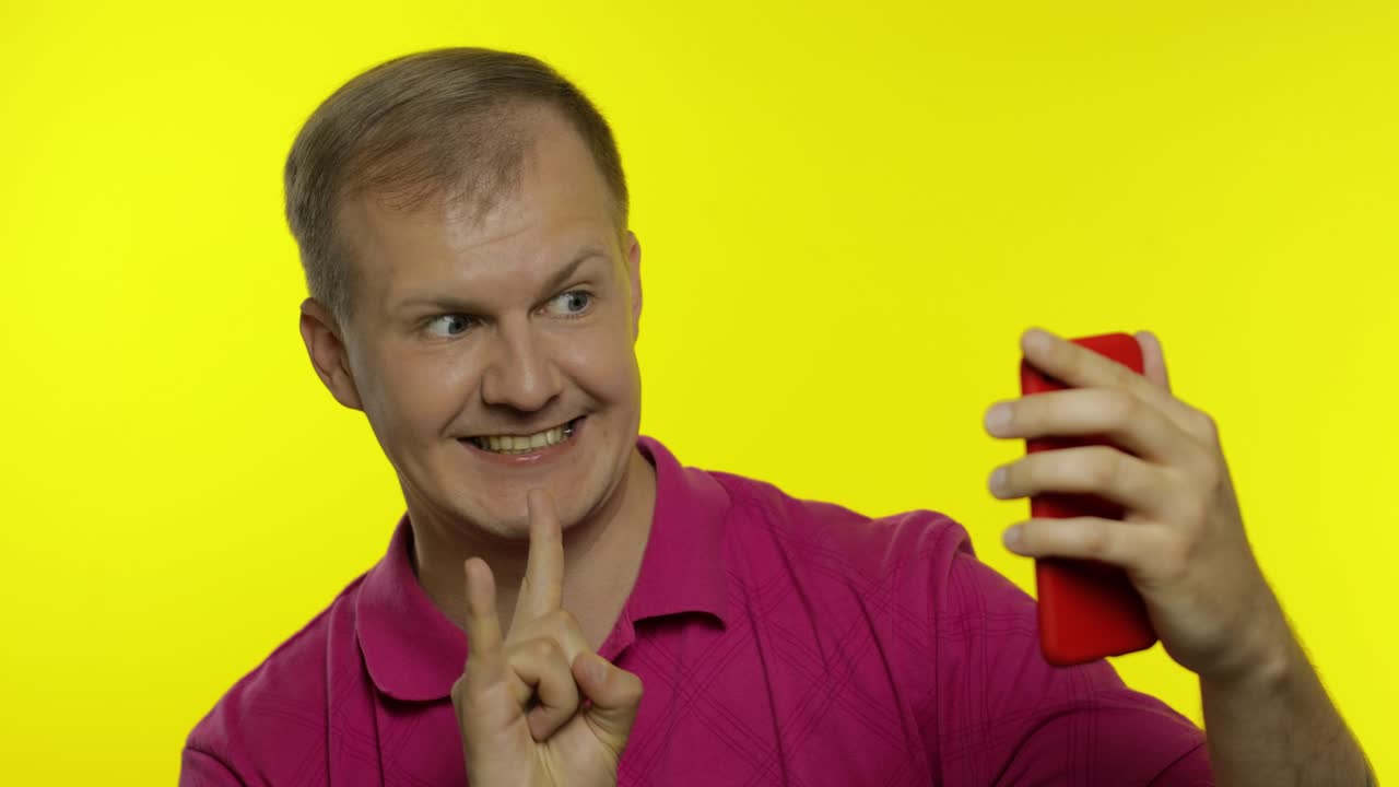 Portrait of young caucasian man posing in t-shirt. Handsome guy taking selfies on the smartphone