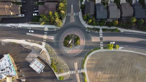 descending shot of roundabout in bend, oregon with cars driving around it