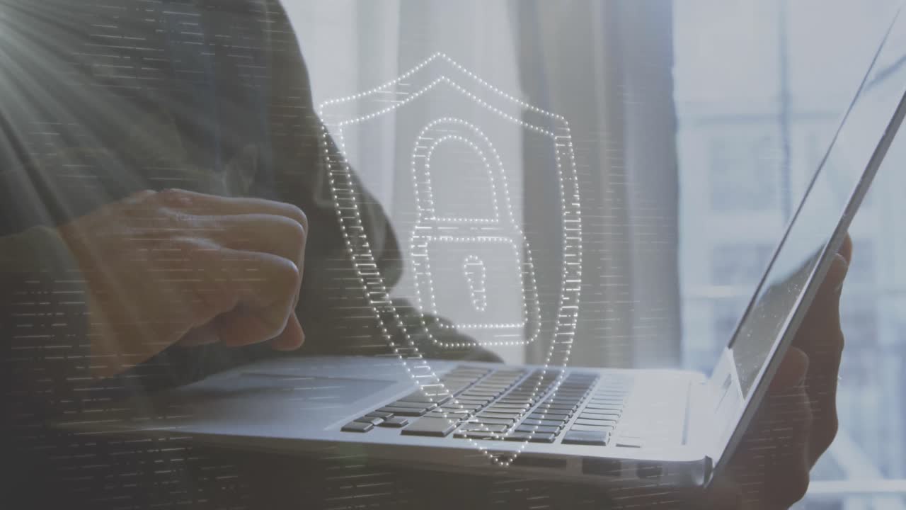 animación de un candado en el escudo sobre la sección media de un hombre caucásico usando una computadora portátil en casa