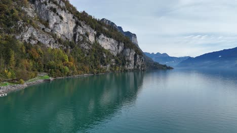 Drone-flyover-idyllic-Lake-Walen-with-swiss-mountains-in-background-during-daylight---Weesen,-Switzerland