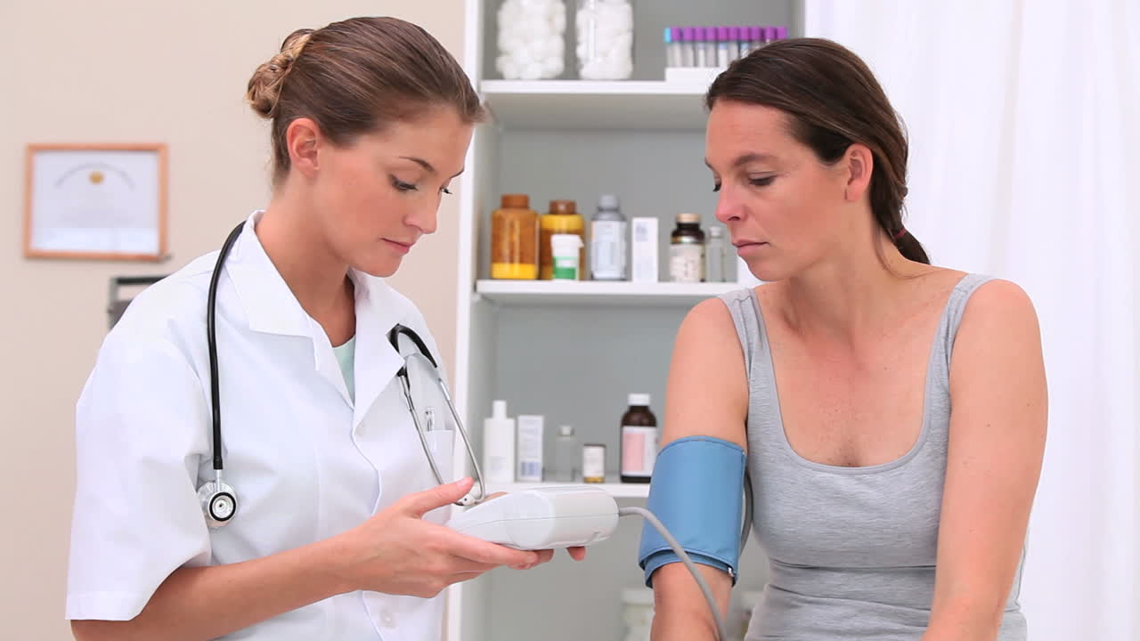 médico que toma la presión arterial de un paciente