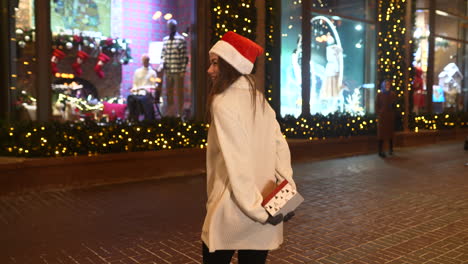 woman with santa hat and gift on a christmas night