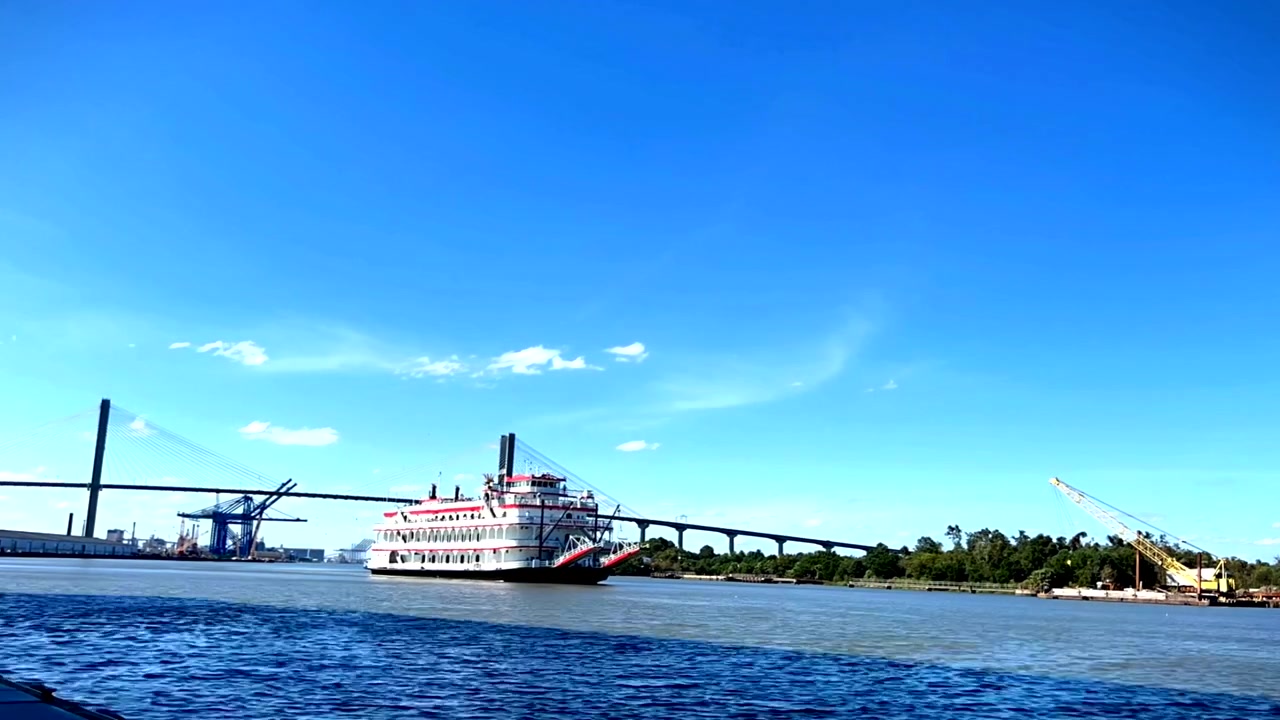 Time-lapse af en flodbåd, der sejler på en åben flod, med maleriske landskaber langs vandkanten.