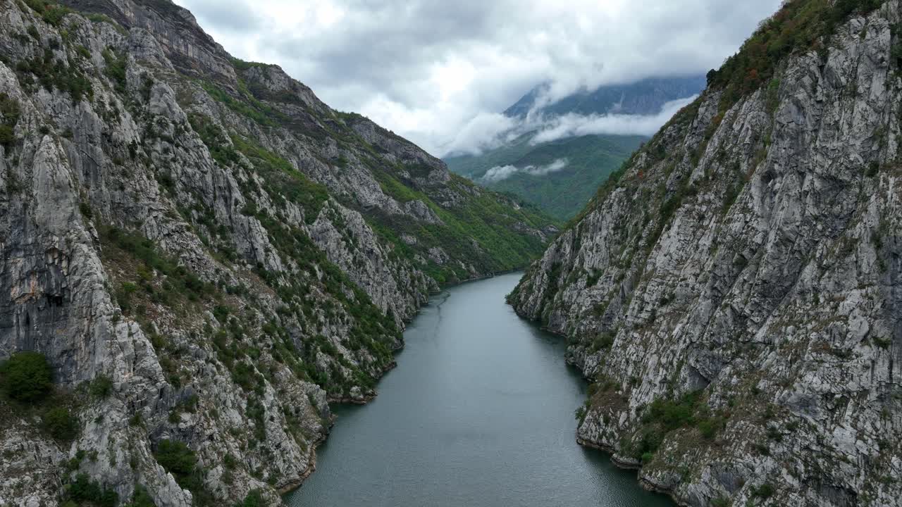 Frontal traveling over Lake Komani surrounded by hills in Albania.