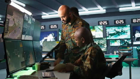 equipo de oficiales militares que usan equipos de seguimiento para obtener información